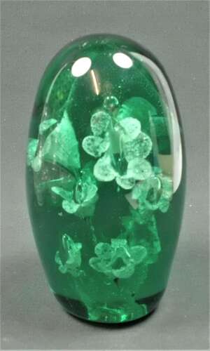 A heavy dark green glass 'dump' (door stop) with flower inclusions, English circa 1860