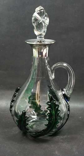 A crystal glass jug with applied green glass leaves and silver mount, Birmingham 1918